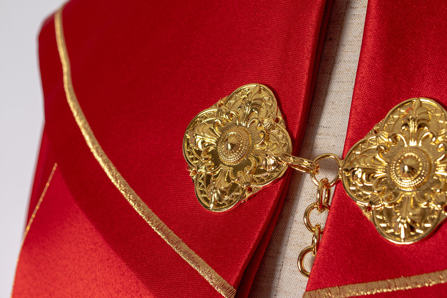 Roter liturgischer Umhang mit goldenem Monogramm