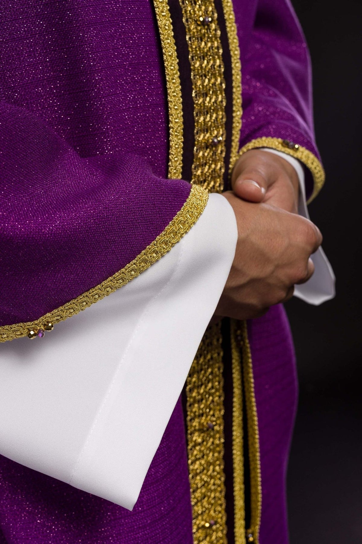 Kasel im Detail: violetter Stoff und goldene Abschlussborte am Ärmel