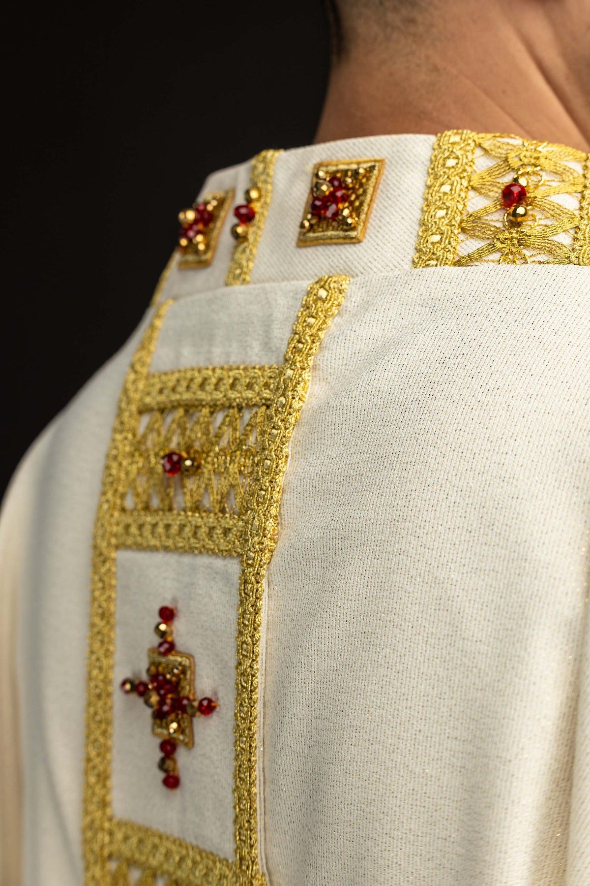 Handgefertigtes Messgewand mit Natursteinen, Detail der goldenen Borte und roten Schmucksteine