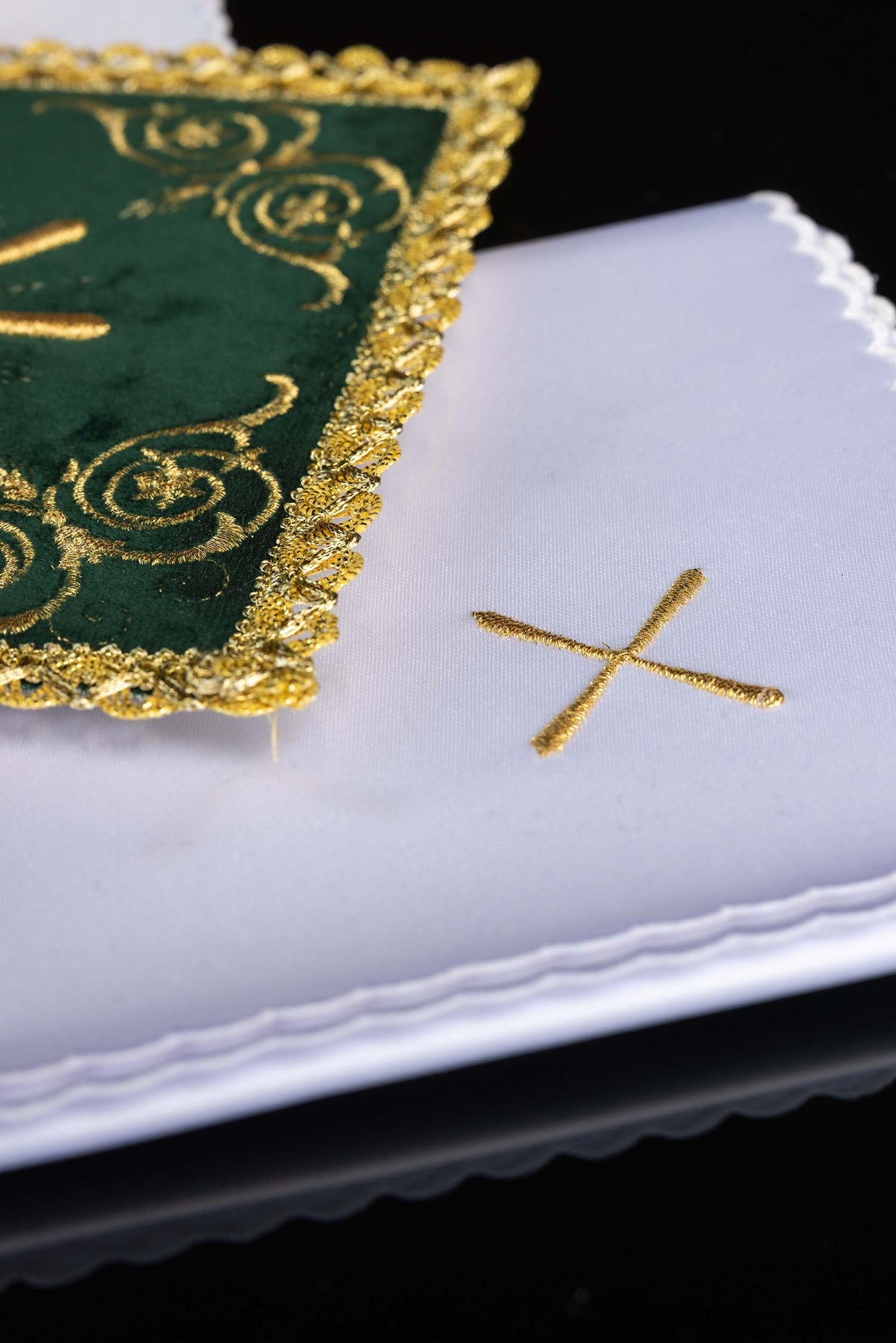 Kelchwäsche aus grünem Samt, Detail der weißen Tücher mit goldenen Kreuzen