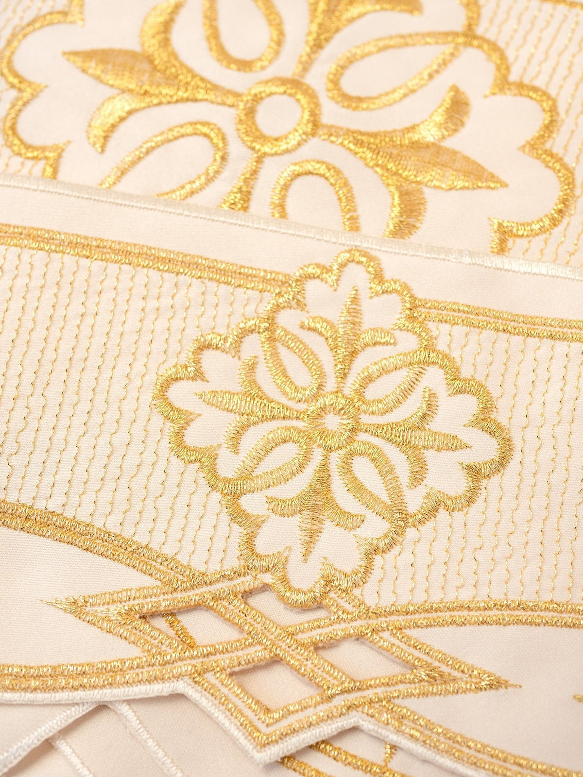 Meterware Rosette Ecru als Detailaufnahme der goldenen Rosetten- und Rankenstickerei