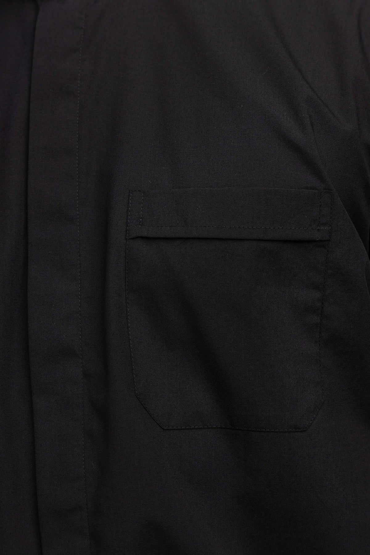 Schwarzes Klerikerhemd mit aufgesetzter Brusttasche im Detail
