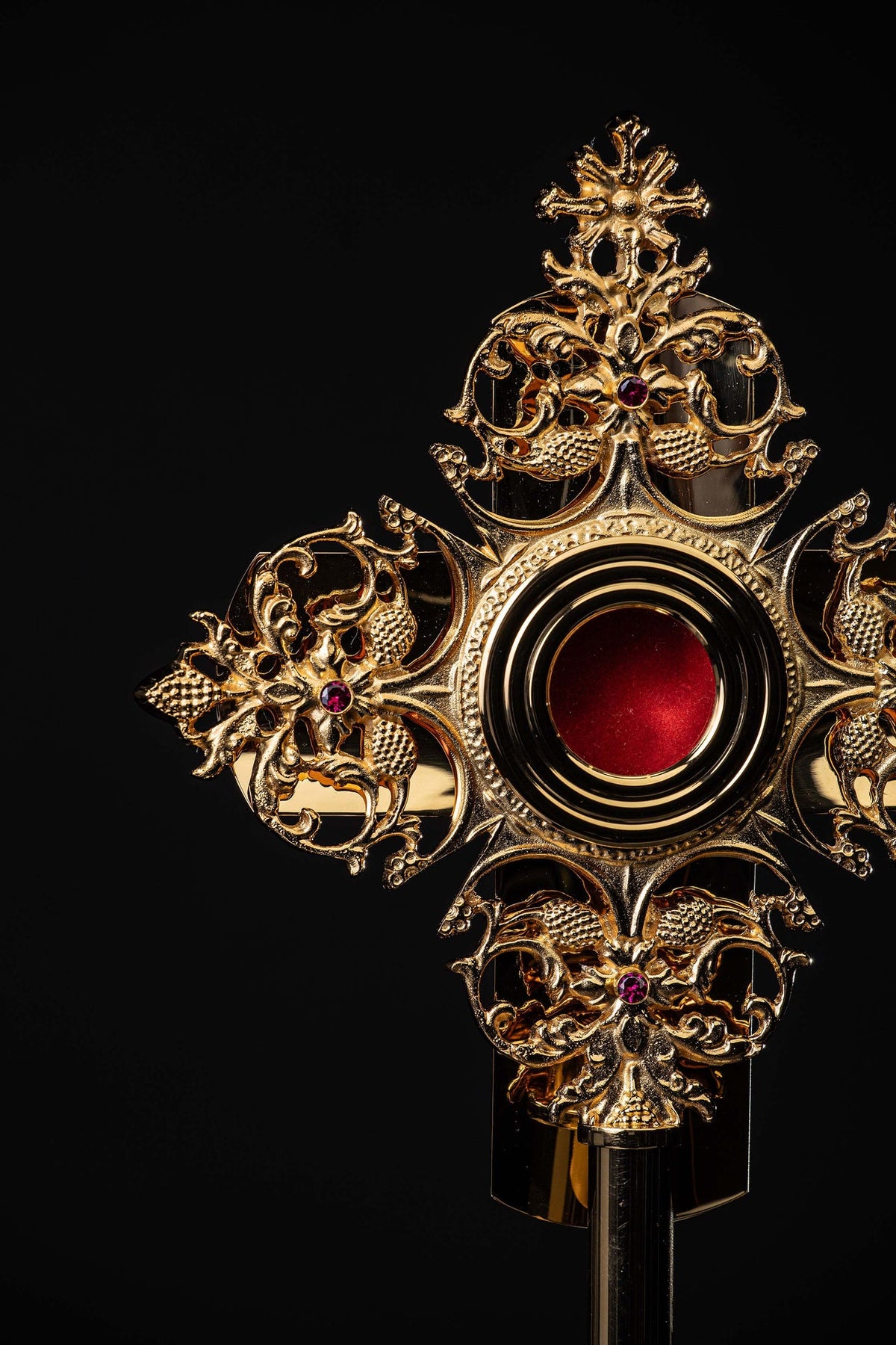 Reliquiar aus vergoldetem Messing als Nahaufnahme mit filigranen Ornamenten und roter Mitte