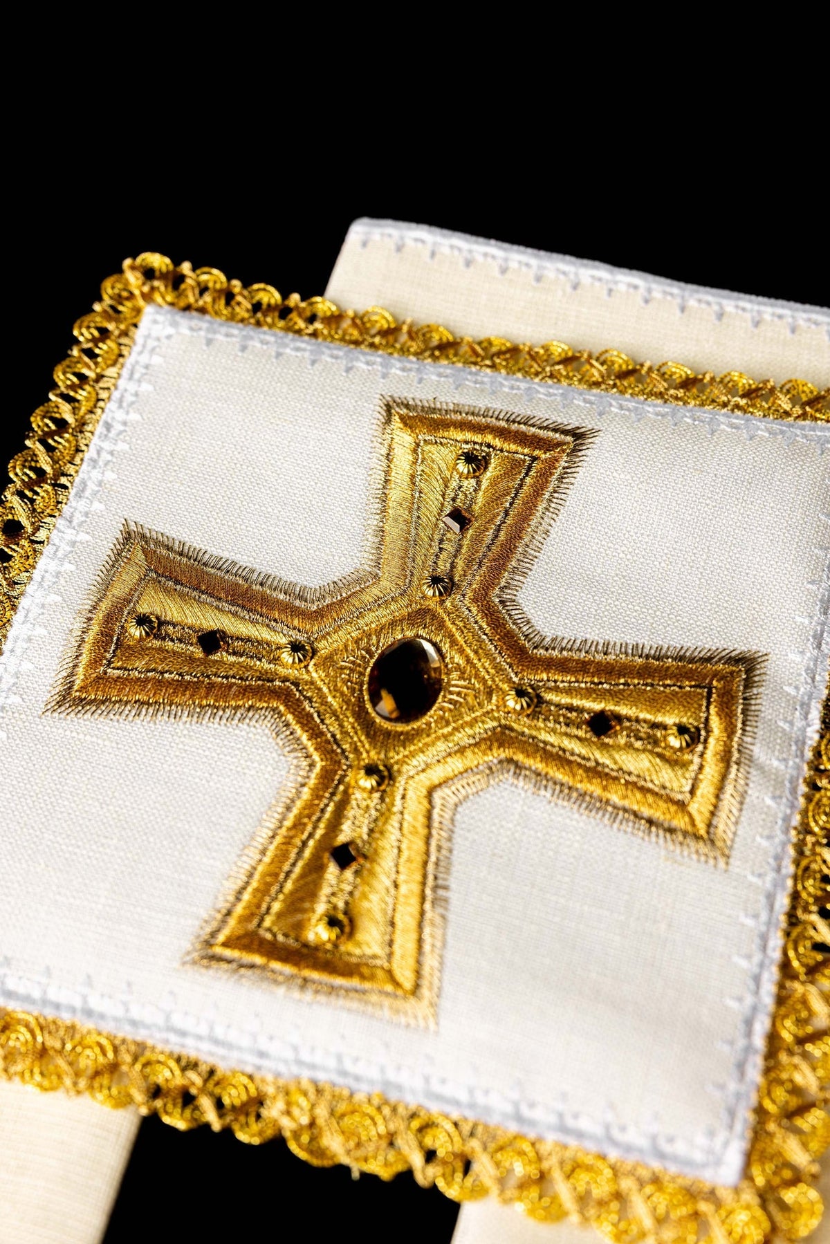 Kelchwäsche-Set, Nahaufnahme des goldbestickten Kreuzes mit bernsteinfarbenem Stein