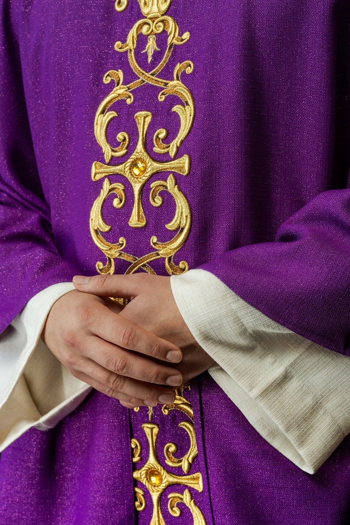 Violettes Messgewand im Detail mit goldener Stickerei und eingesetztem Stein