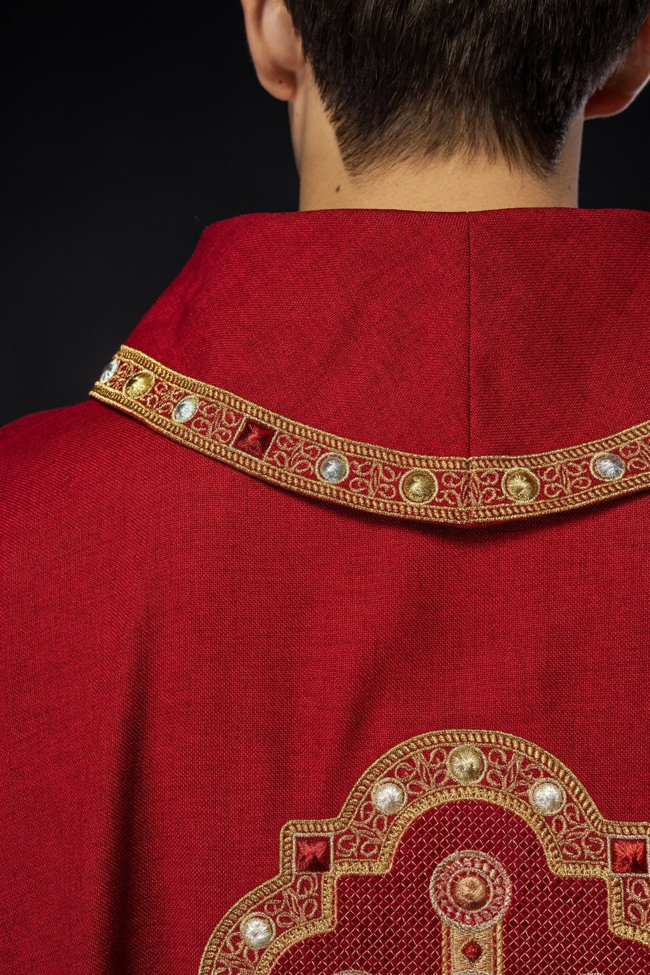 Ornat w kolorze czerwonym z haftowaną lamówką na kołnierzu i wokół haftu krzyża