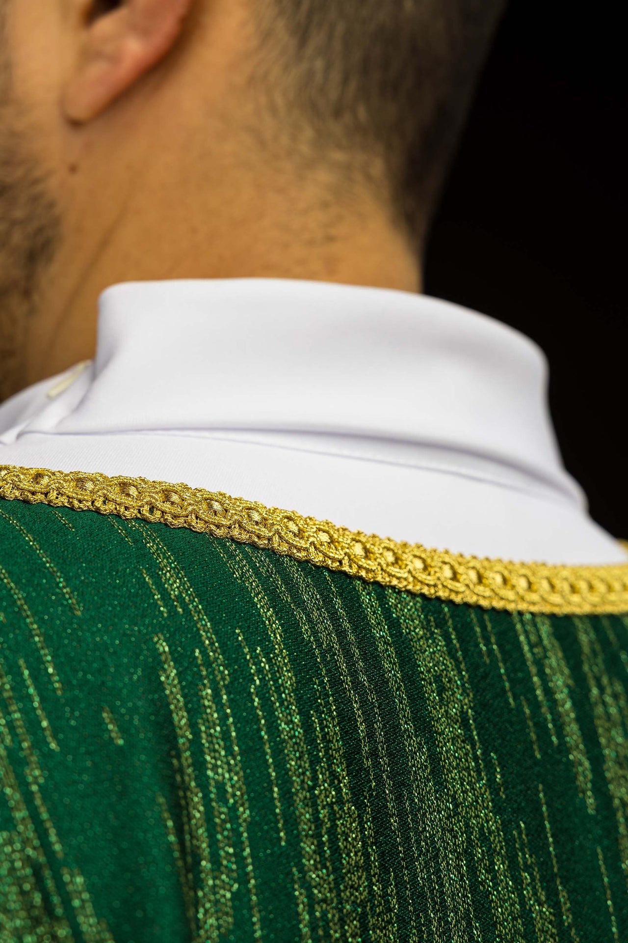 Grüne Kasel mit gesticktem Kreuzmotiv auf dekorativem Stoff