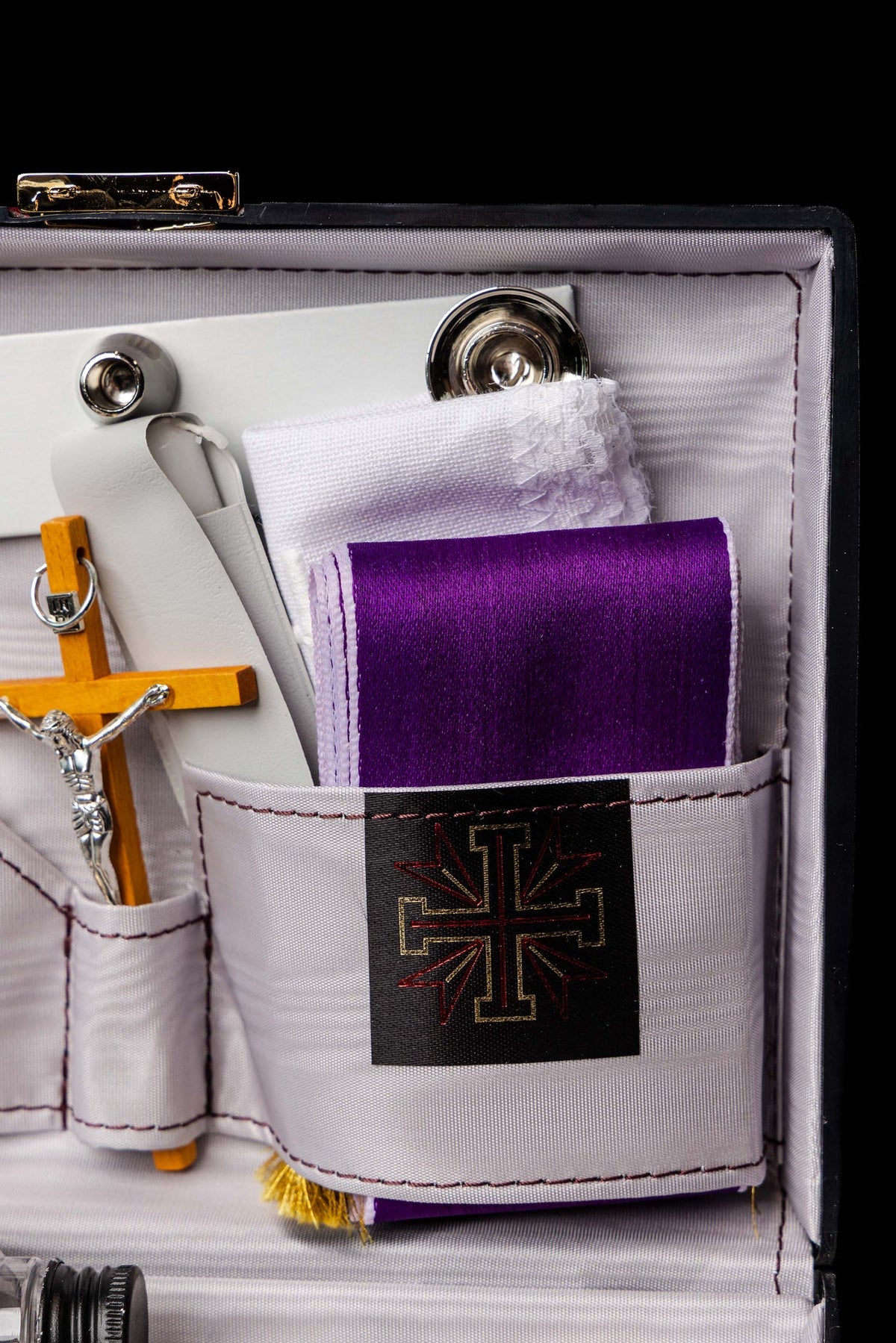 Missionskoffer, Detail des violetten Tuchs mit goldenen Fransen und schwarzem Kreuzemblem