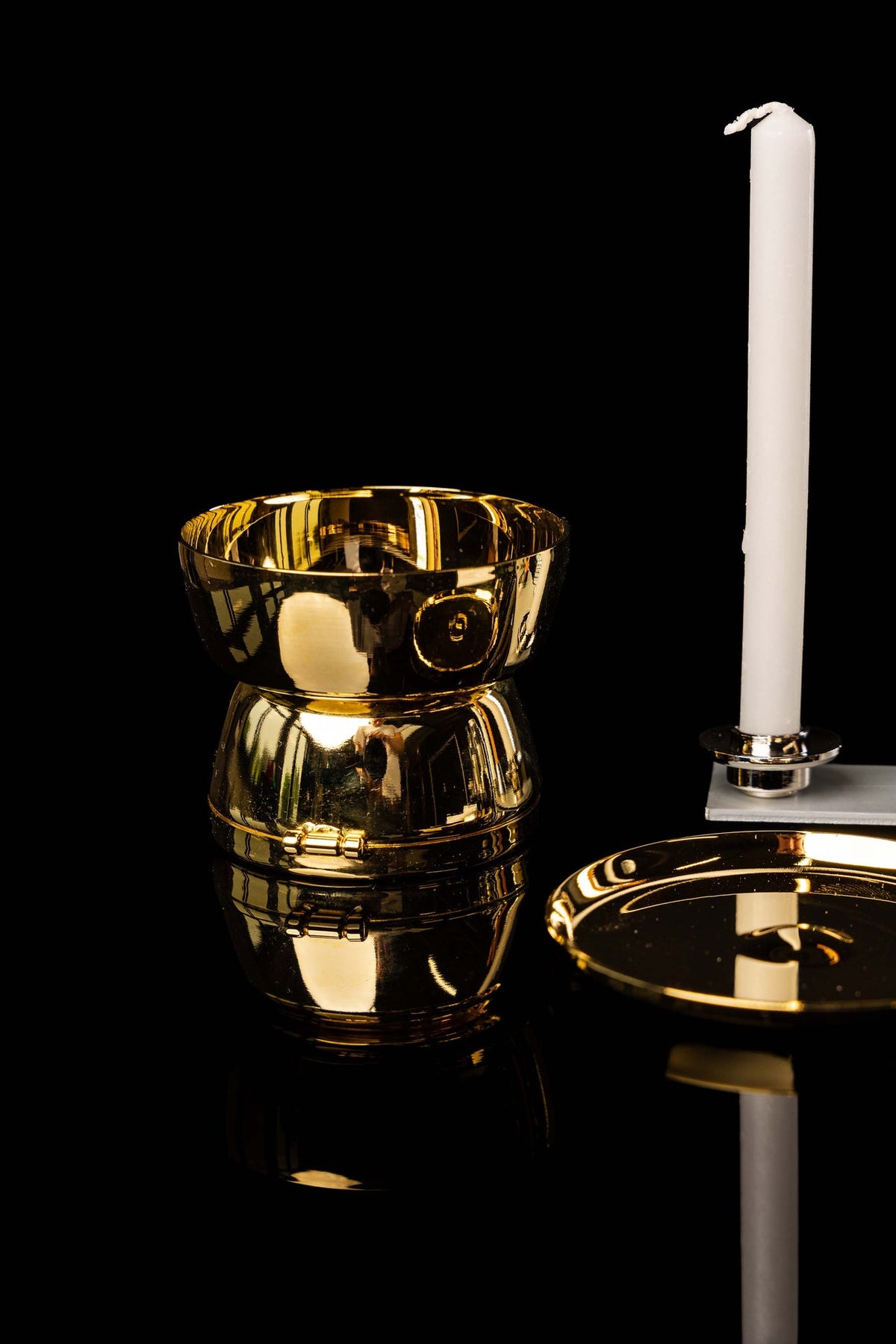 Missionskoffer, goldener Kelch mit Deckel neben einer weißen Kerze