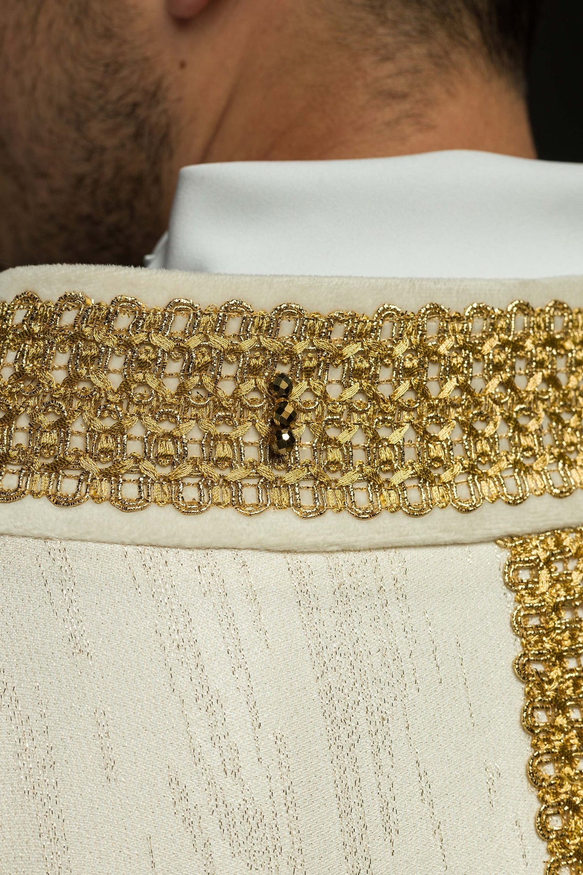 Handgefertigte Kasel in Ecru, Detailaufnahme der goldenen Borte mit natürlichen Steinen