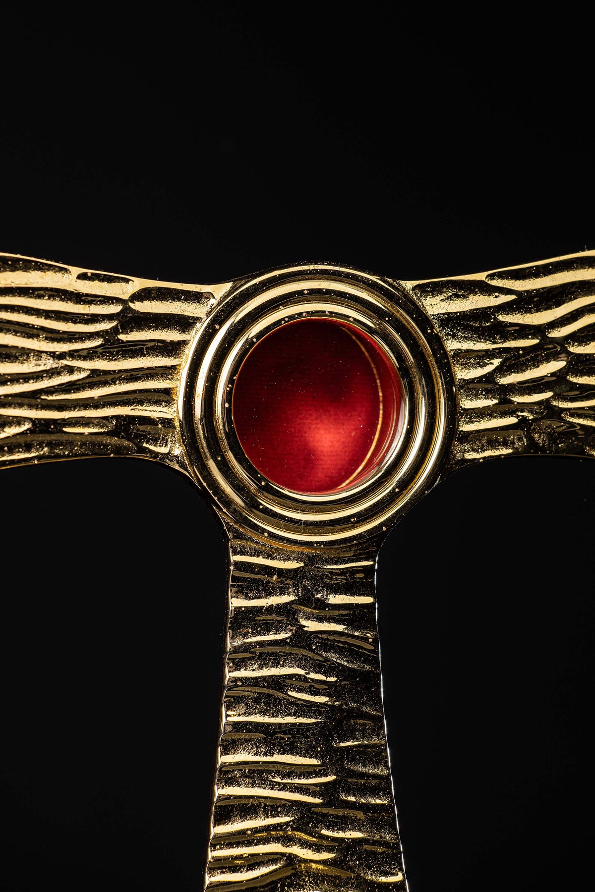Taukreuz-Reliquiar aus Messing, Nahaufnahme der roten runden Reliquienfassung