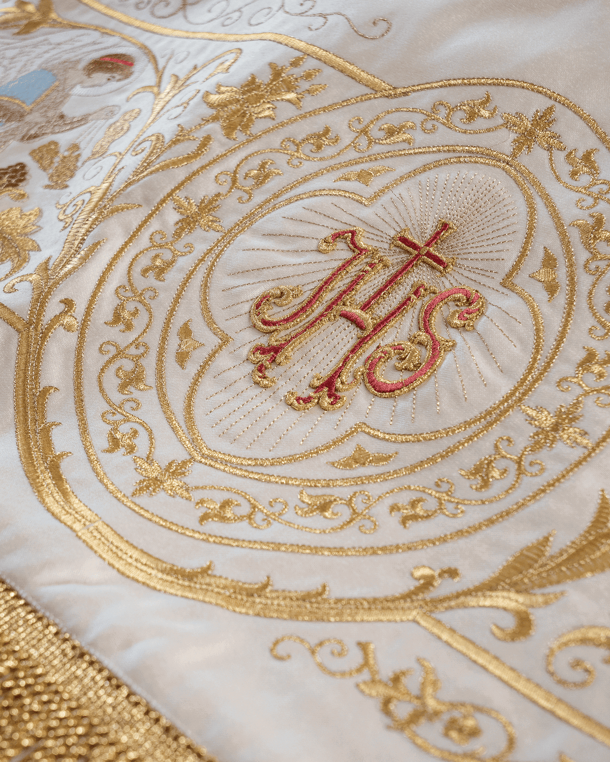 Prozessionshimmel mit Nahaufnahme des IHS-Motivs in goldener Ornamentstickerei