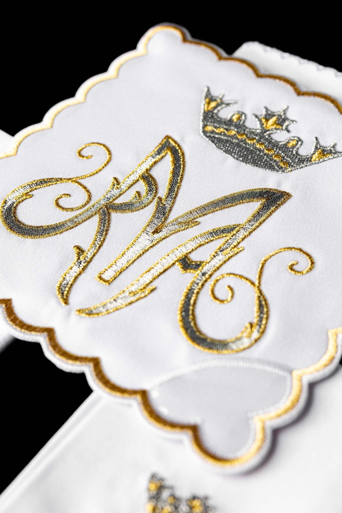 Kelchwäsche-Set, Nahaufnahme des gold-silbernen Marienmonogramms mit Krone