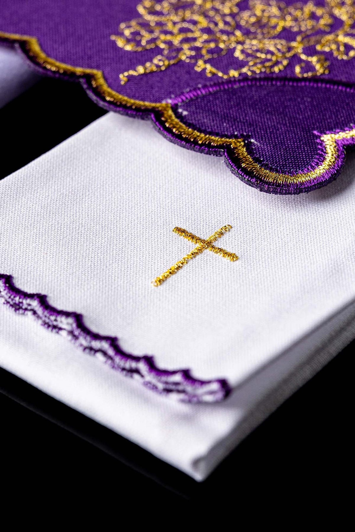 Kelchwäsche-Set, Detail der weißen Tücher mit violetter Bogenkante und goldenem Kreuz