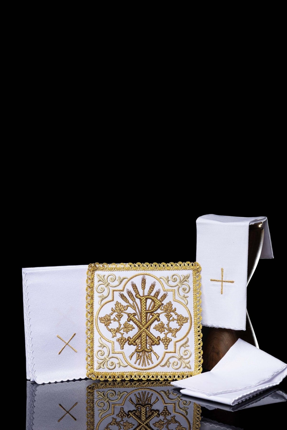 Kelchwäsche mit gesticktem PAX-Symbol, weiße Tücher mit goldener Stickerei und goldener Borte