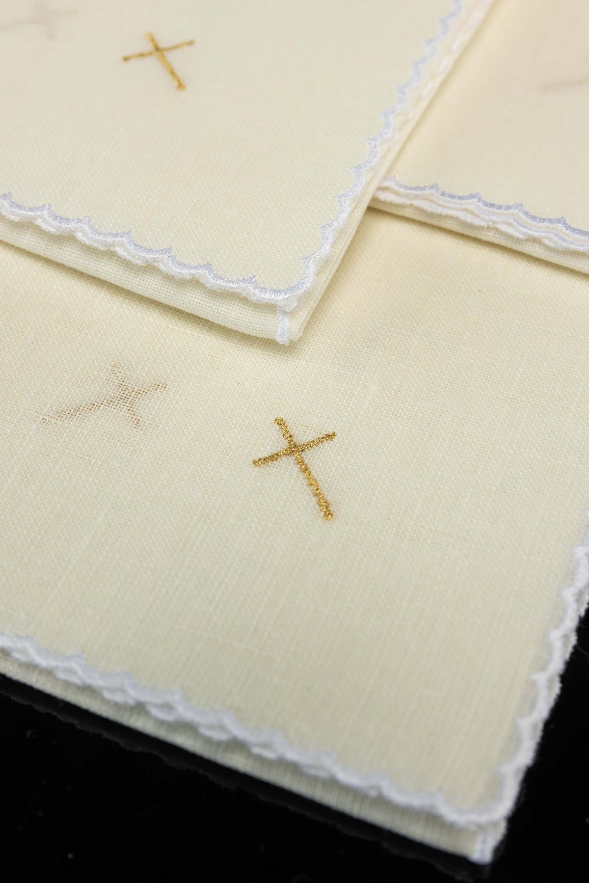 Corporale aus Leinen im Detail mit goldenem Kreuz und gewelltem Rand