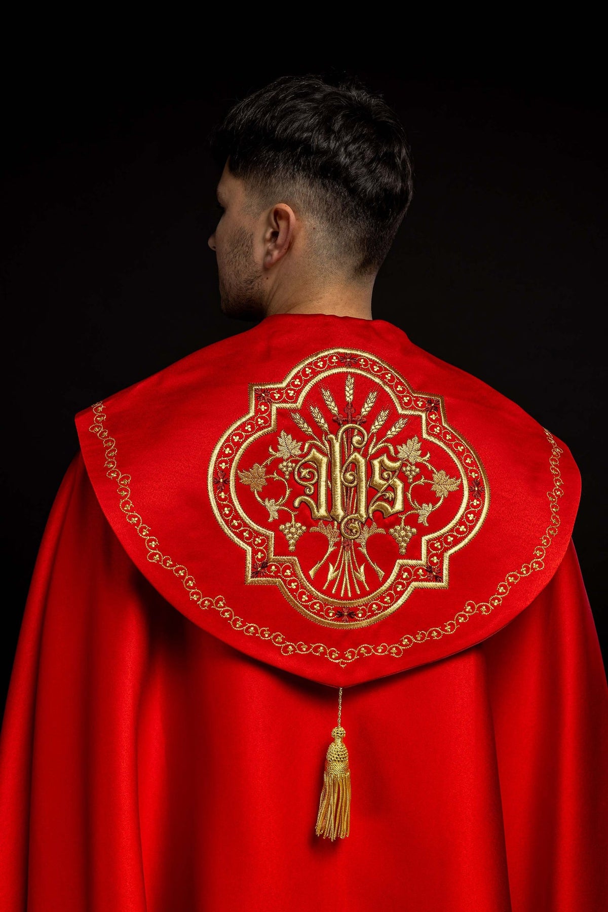 Roter liturgischer Rauchmantel mit IHS-Stickerei, Rückansicht mit goldener IHS-Stickerei und Quaste