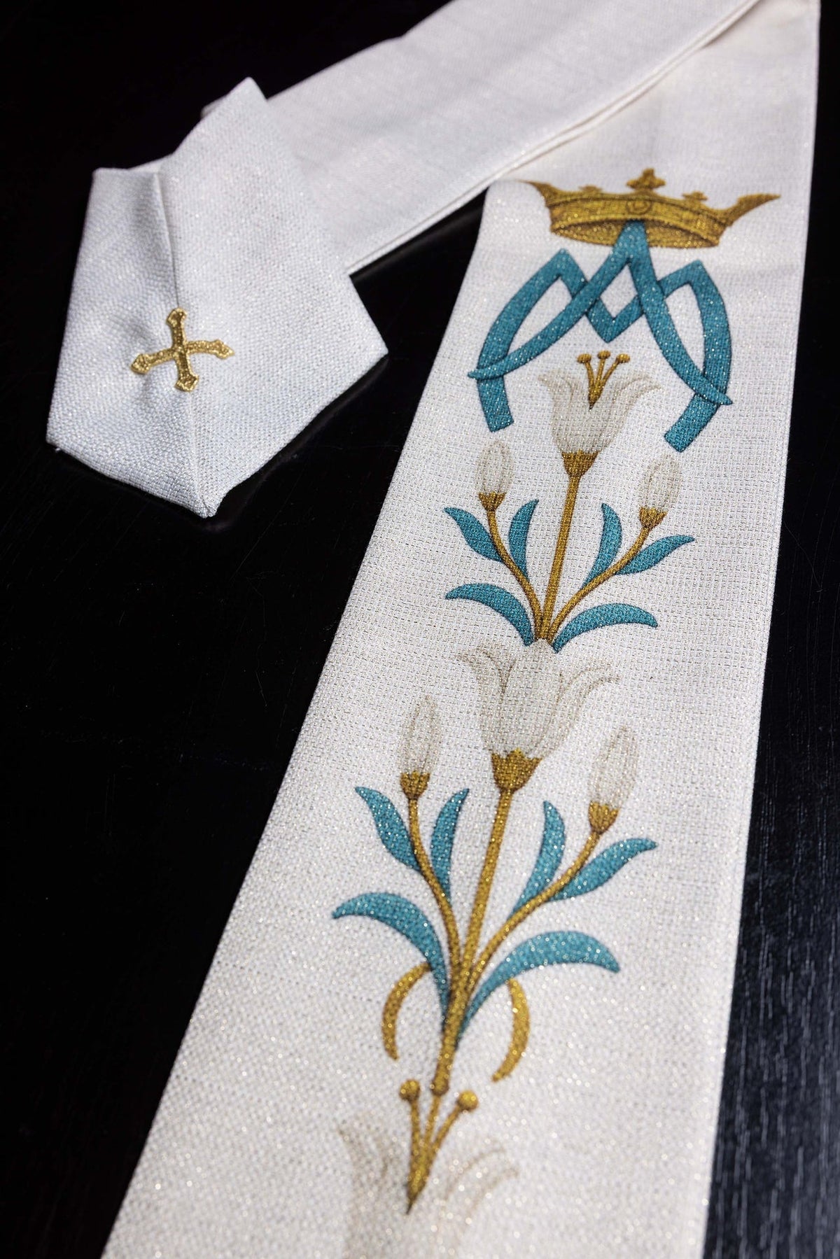Gedruckte Marien-Kasel mit Lilienmuster und Monogramm Ecru, Detail mit blauem Monogramm und Lilien
