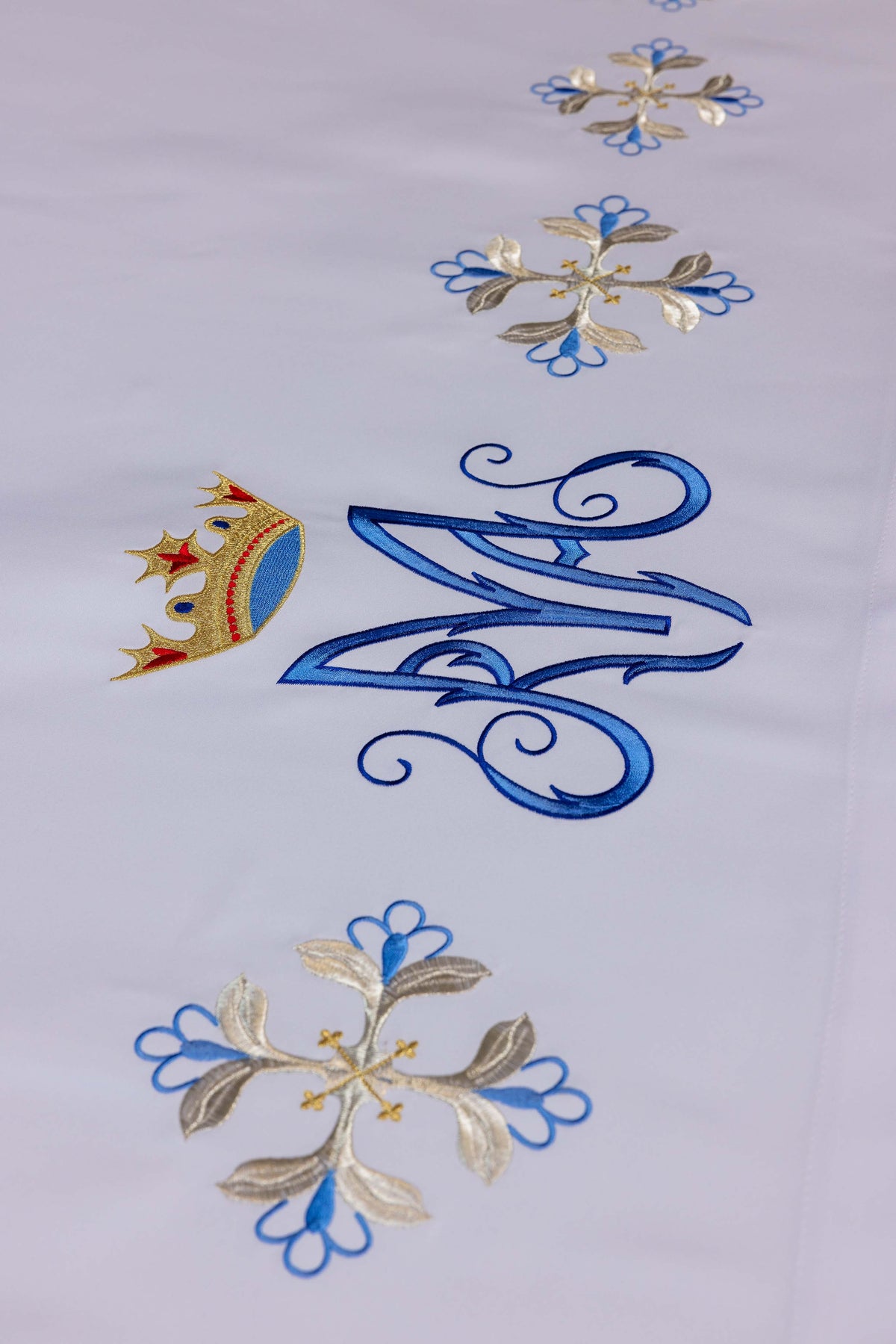 Altartuch mit Marienmonogramm und gold-blauen Kreuzblumen, Detailansicht der Stickerei