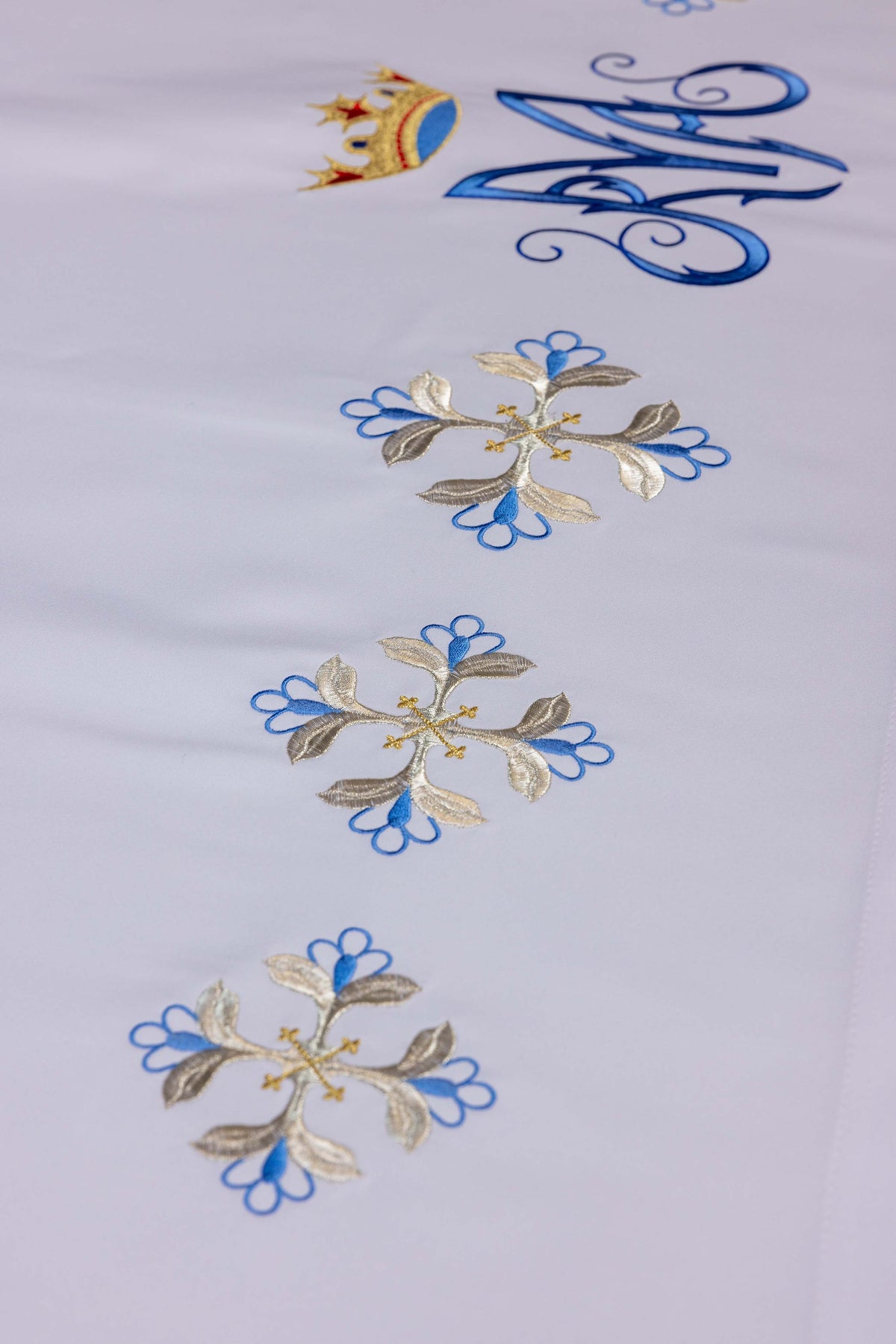 Altartuch mit blauem Marienmonogramm und umlaufenden Kreuzblumen, Nahaufnahme