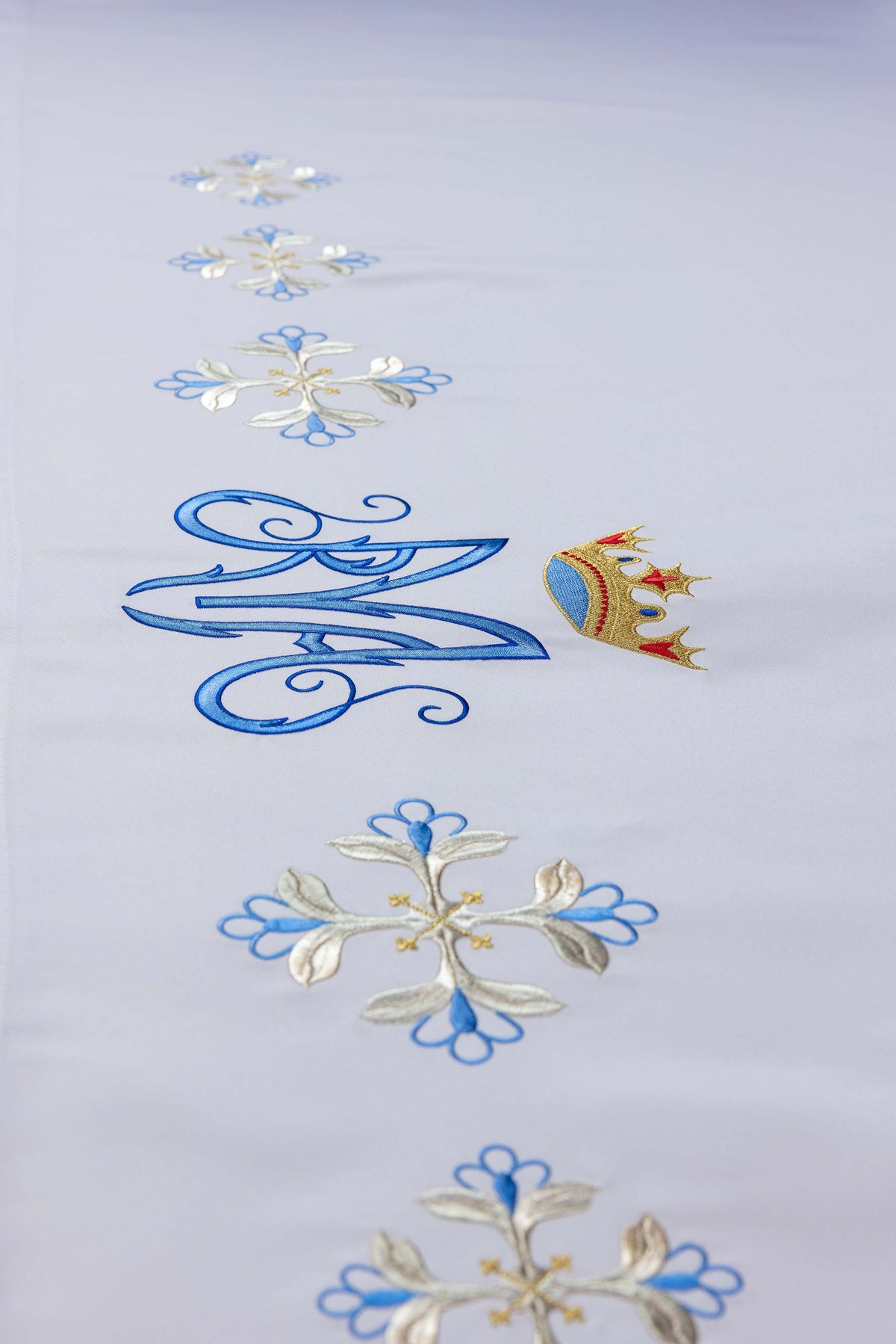 Altartuch mit blauem Marienmonogramm, Krone und bestickten Kreuzblumen, Detailansicht