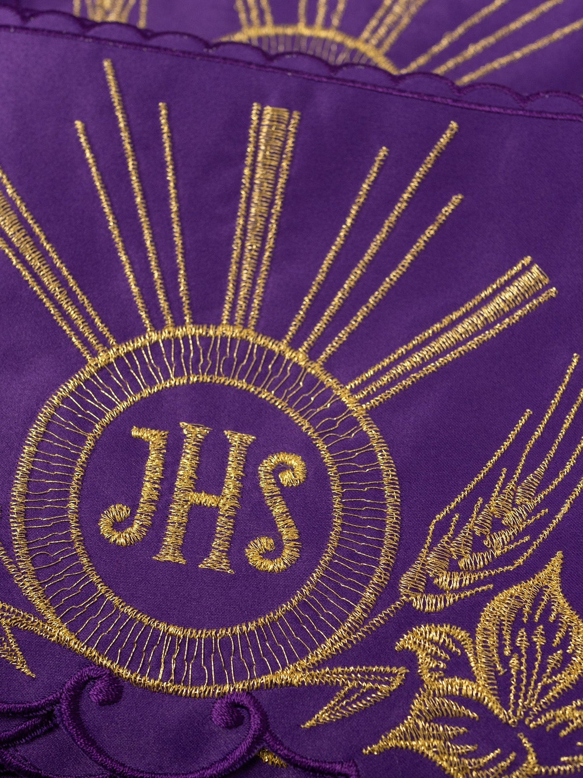 Violetter Meter, Nahaufnahme der goldenen IHS-Stickerei mit Strahlen und Blumenornament