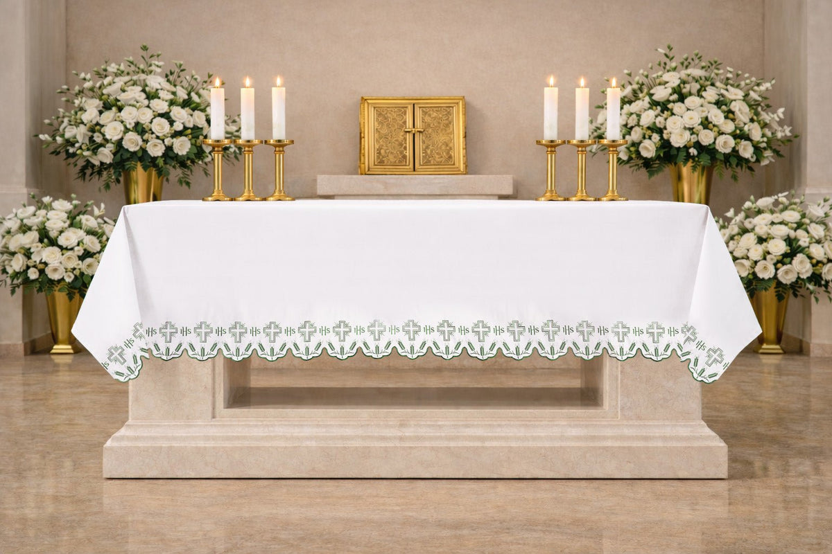 Altartuch mit grün bestickten Kreuzen und dekorativem Abschluss, frontal am Altar