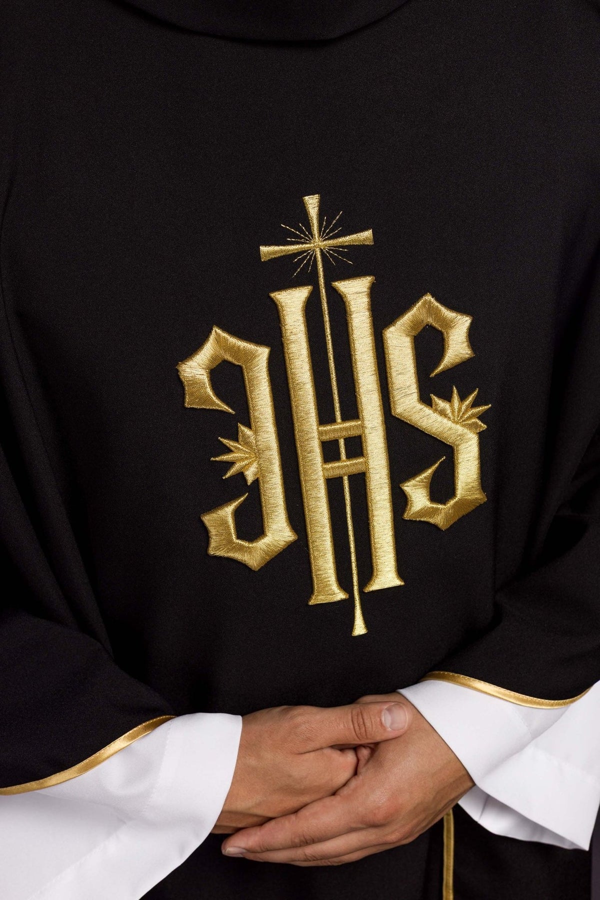Goldene IHS-Stickerei mit Kreuz auf dem schwarzen Messgewand, Detailansicht