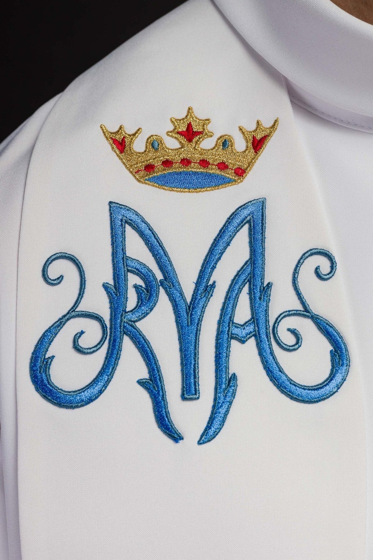 Priesterstola in Weiß, Nahaufnahme des blauen Marienmonogramms mit goldener Krone