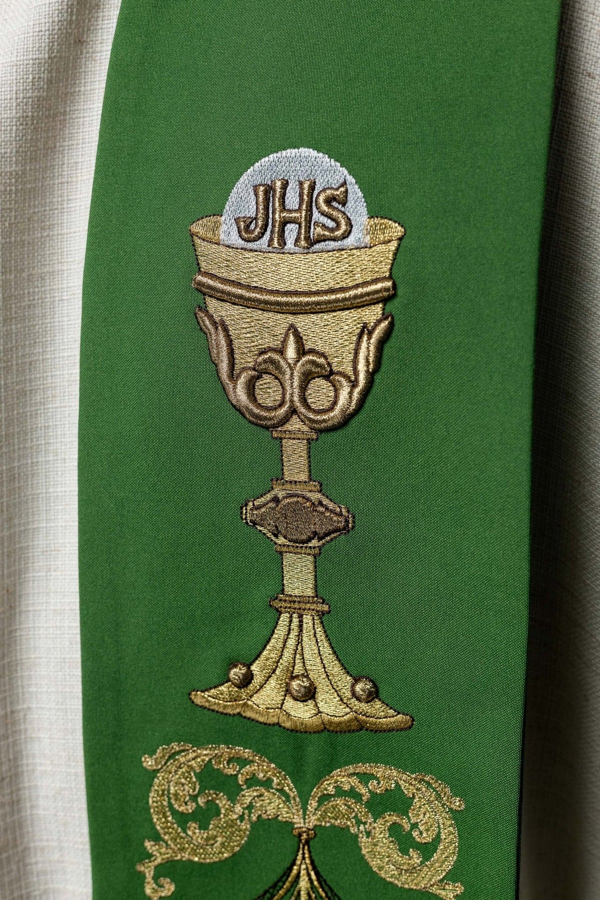 Grüne Priesterstola mit Nahaufnahme der goldenen IHS-Kelchstickerei