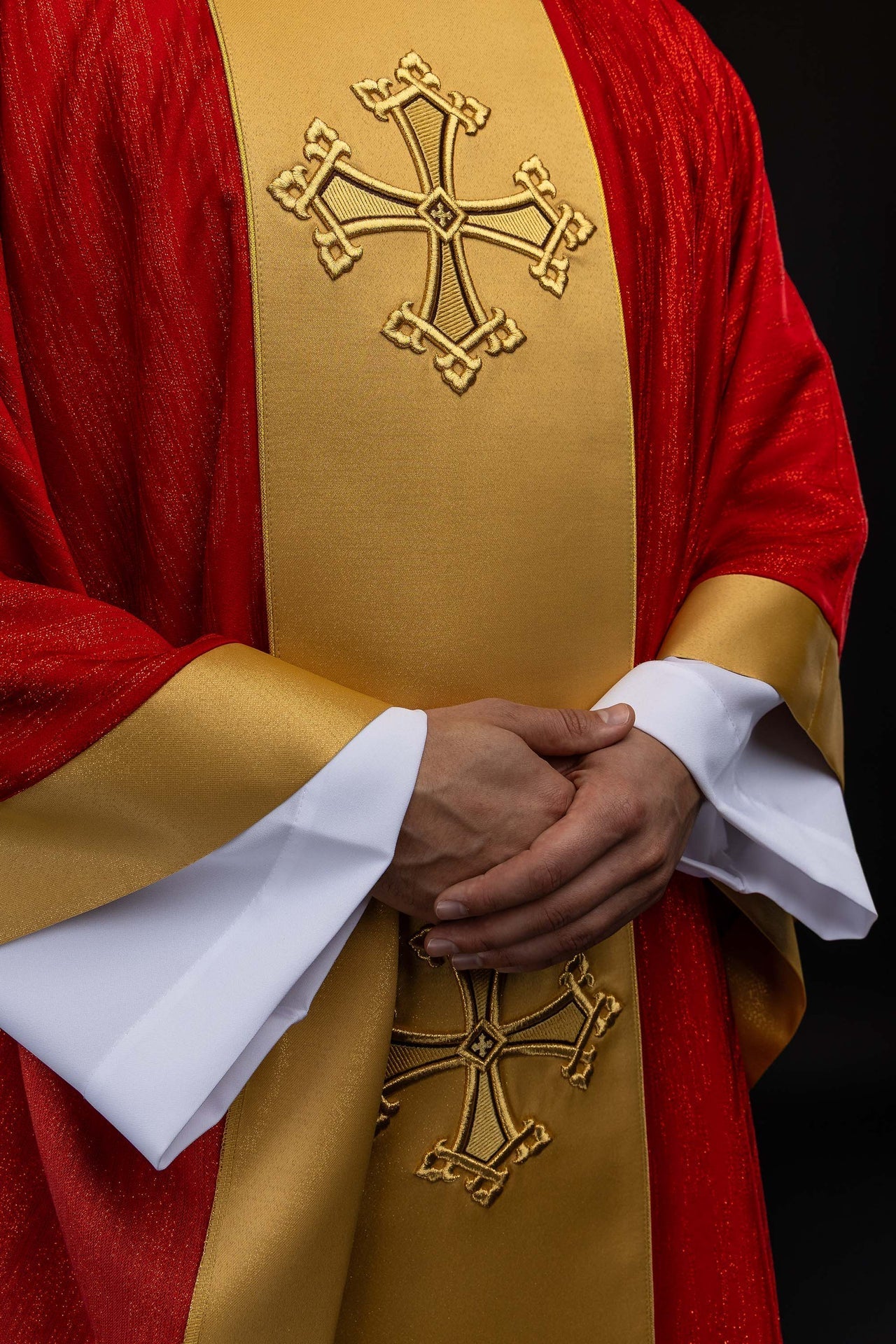 Rote Kasel mit besticktem Kreuzmotiv und Mittelborte auf dekorativem Stoff - MESSGEWANDER.DE