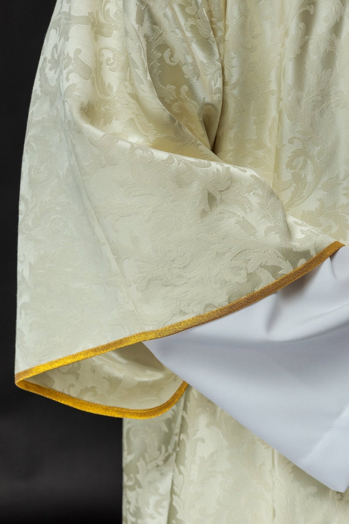 Dalmatik mit Osterlamm, Detail des Ecru-Stoffs und goldener Saumkante