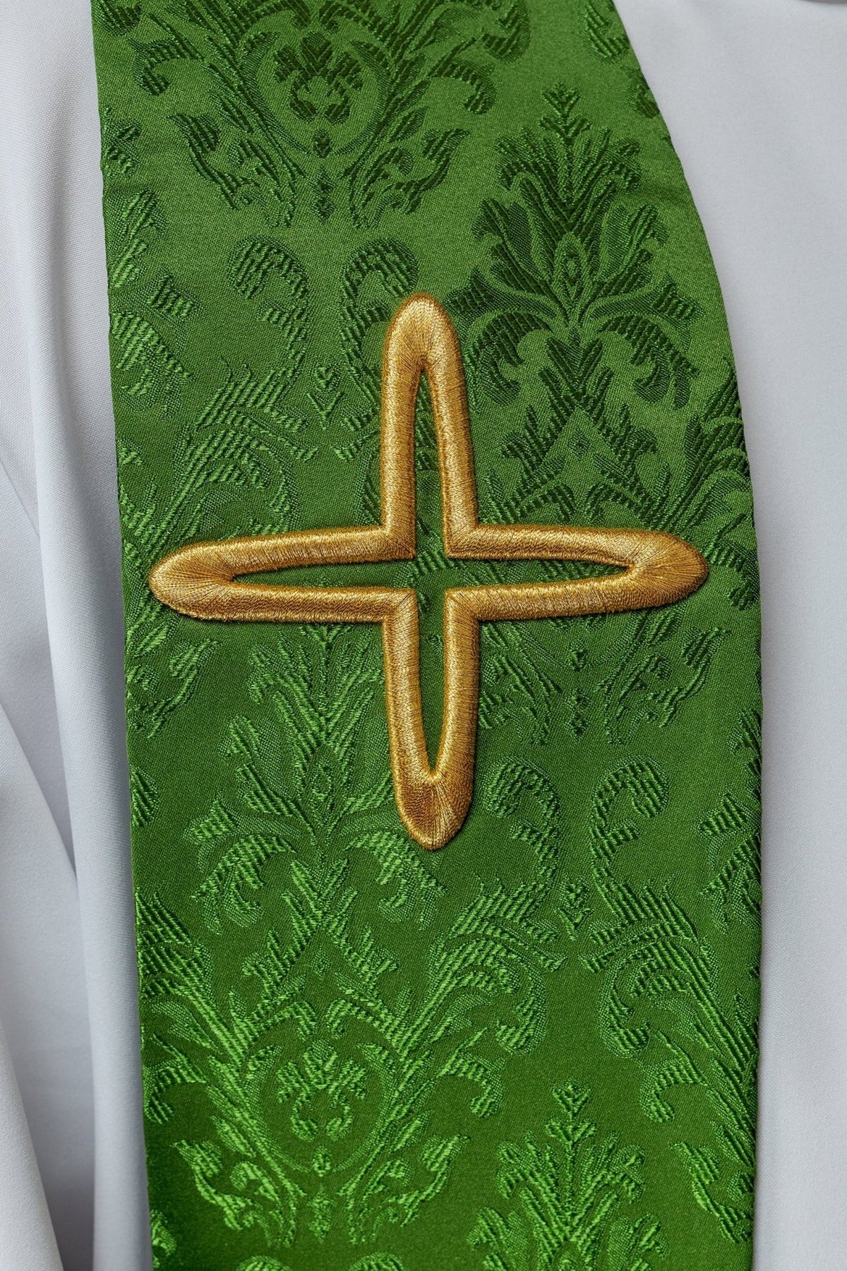 Grüne Stola im Detail mit großem goldenen Kreuz und Jacquardmuster