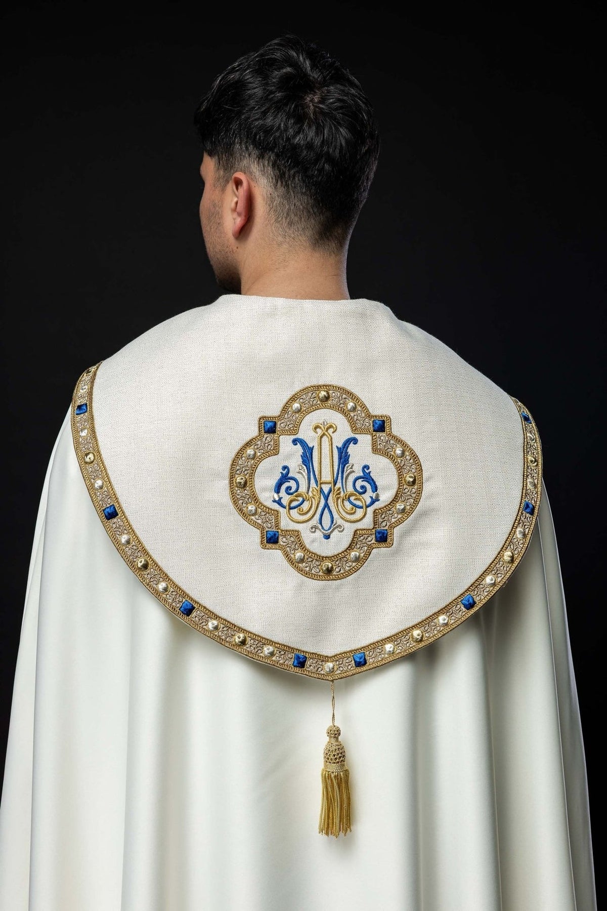 Liturgischer Rauchmantel mit gesticktem Marienwappen, Rückansicht in Ecru mit gold-blauer Borte und Quaste
