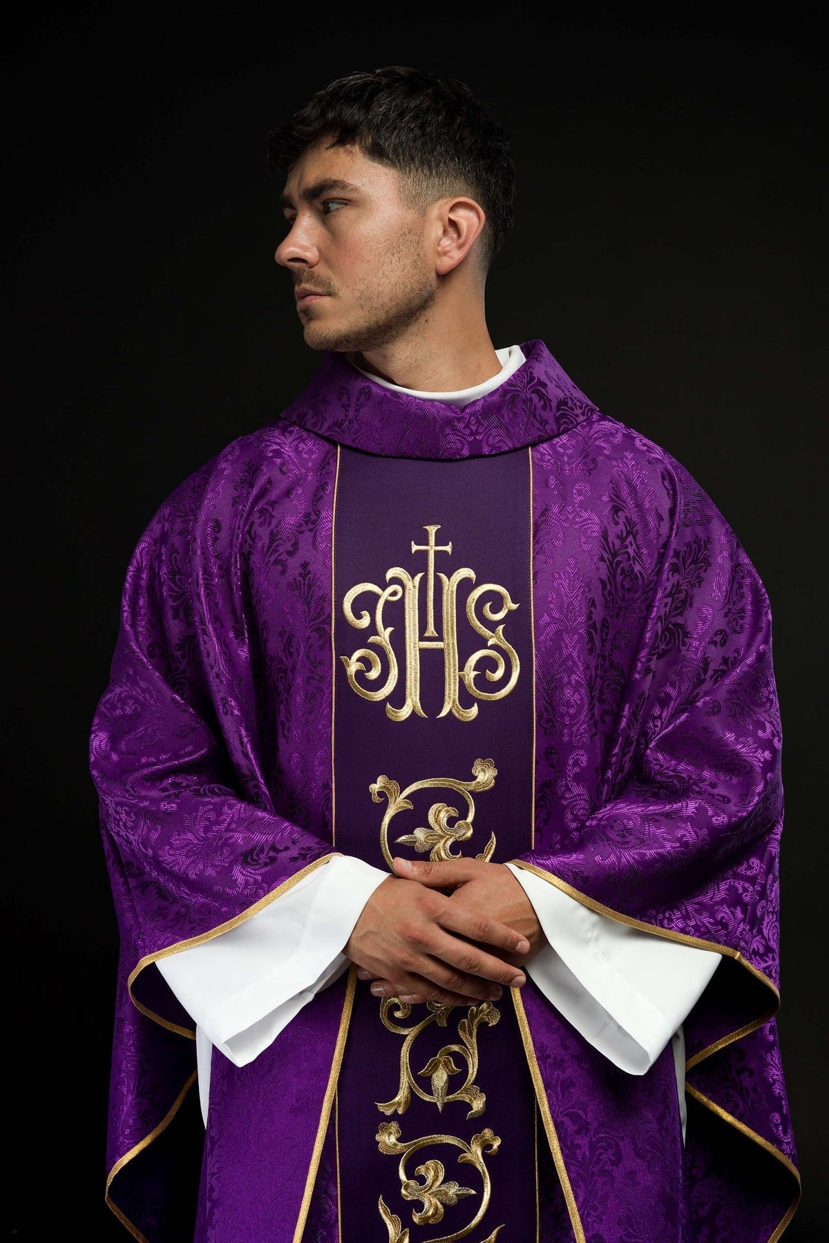 Lila liturgisches Messgewand mit reich verziertem IHS-Gürtel, vorne getragen, mit goldener IHS-Stickerei