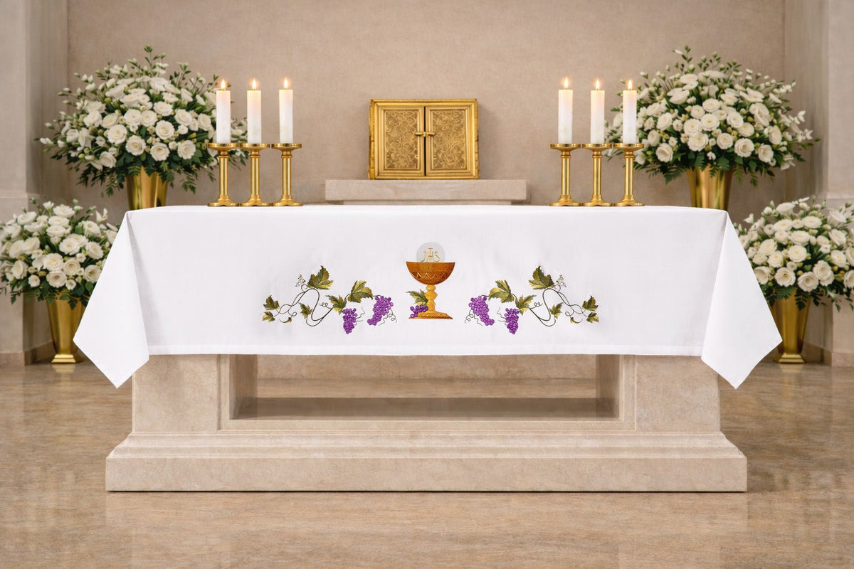 Altartuch mit gesticktem Kelchsymbol, weiß, frontal am Altar mit Kelch, Hostie und Weinranken